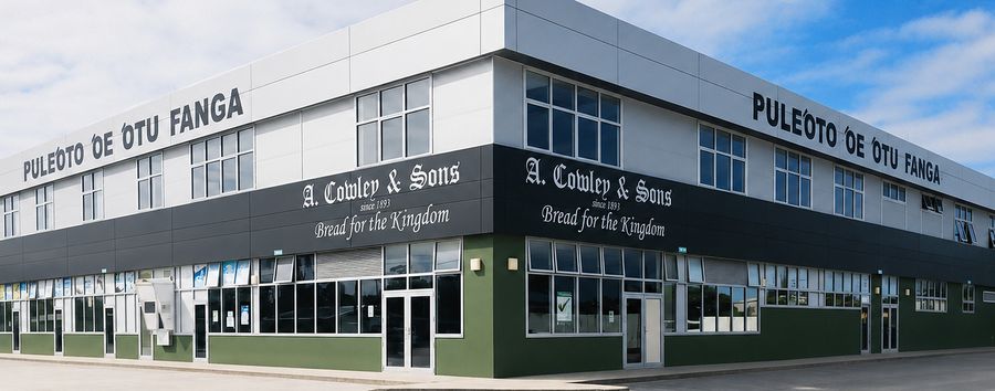 The Cowley Bakery on its corner site, lettered Pule‘oto ‘o e ‘Otu Fanga along the parapet and A. Cowley & Sons, since 1893, Bread for the Kingdom beneath it.