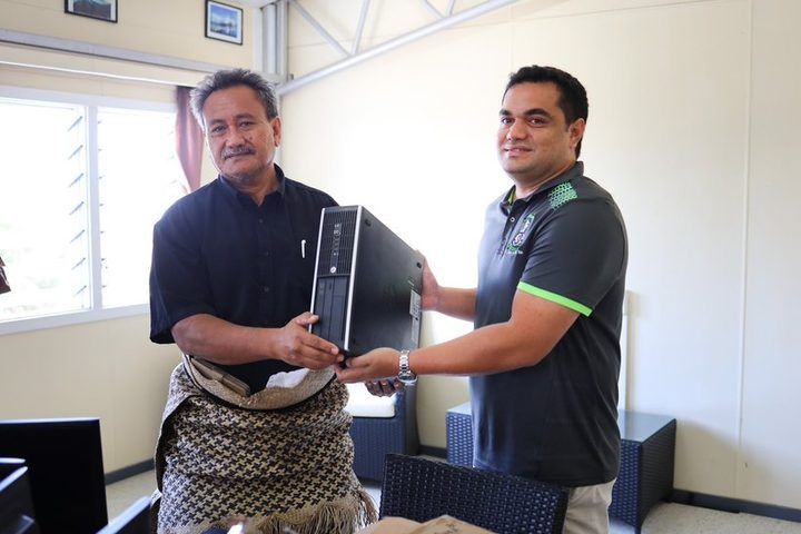 A donated desktop computer being handed over at the Ministry of Education.