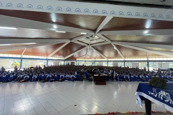 The full school assembly seated in the hall, with the band at the centre.