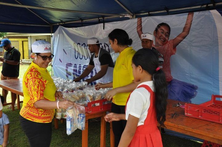 ACS and Anchor volunteers packing lunches under the marquee at the school.