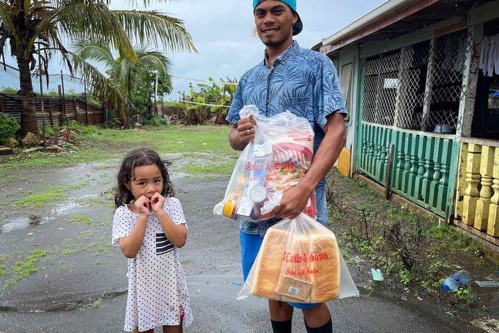 A father and his daughter with their bread and food parcel.