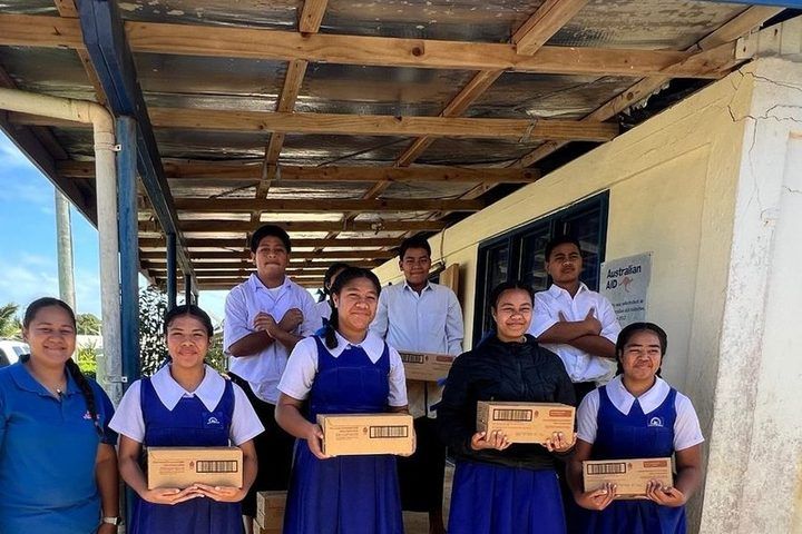 Students with their boxes of milk at the classroom steps.