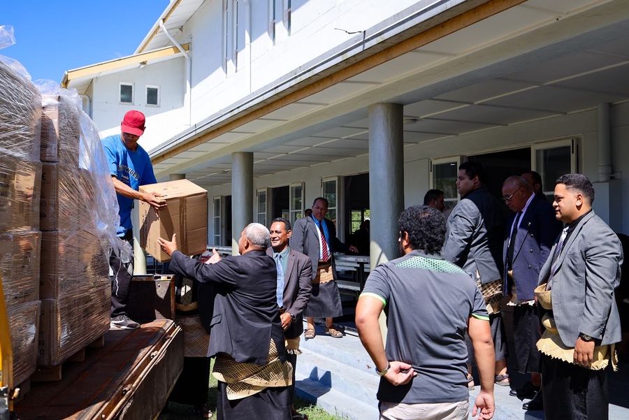 Boxes of masks passed hand to hand from the truck into the building.