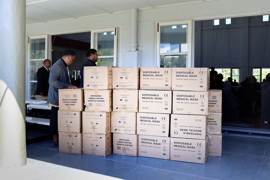 Cartons of disposable medical masks stacked on the veranda, ready to be shared out.