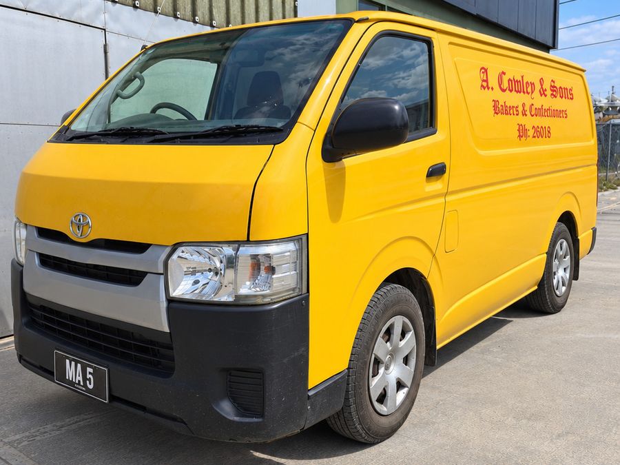 A yellow Toyota HiAce van lettered A. Cowley & Sons, Bakers & Confectioners, Ph 26018, in red script.