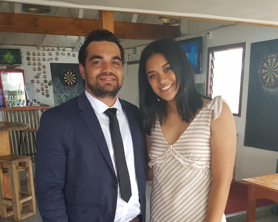 Francis and Kaleti Cowley, the fifth generation, standing together at a function, Francis in a navy suit and tie and Kaleti in a striped dress.