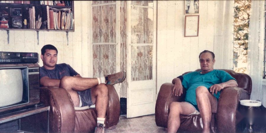 Frank and Alfred Cowley seated in armchairs at home.
