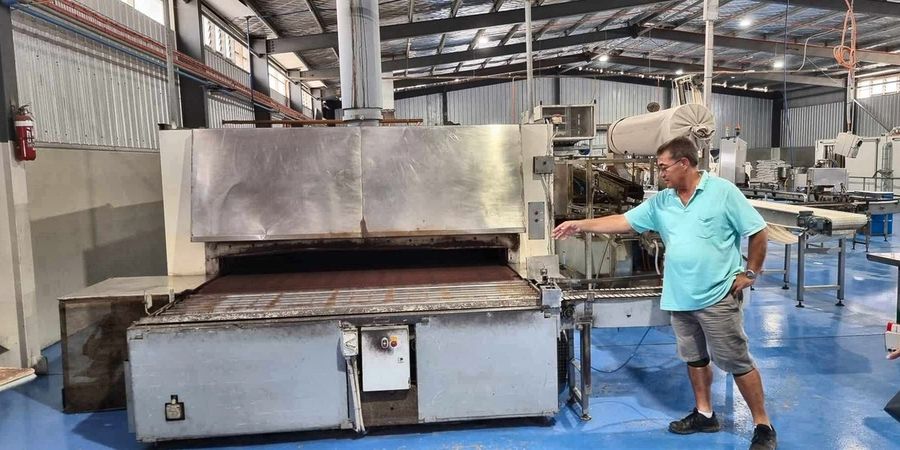 The tunnel oven with its loading end open and the moulding line running alongside.