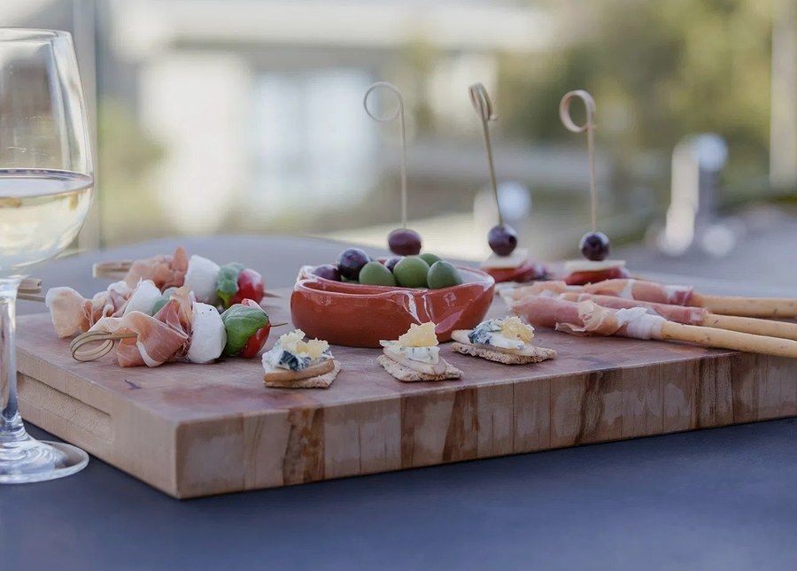 A styled serving board of smallgoods, cheese and olives used for trade and foodservice promotion.